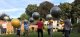 Illustration : Un groupe de personne marche dans un jardin et chacun tient en équilibre sur une main un très gros ballon au dessus de sa tête.
